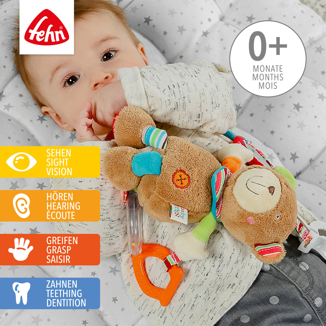 Baby spielt mit Baby Activity-Teddy aus weichem Plüsch