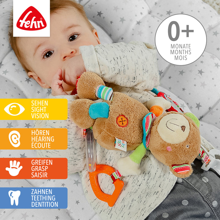 Baby spielt mit Baby Activity-Teddy aus weichem Plüsch