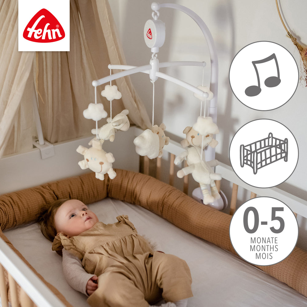 Baby liegt unter Baby Musik-Mobile Schaf