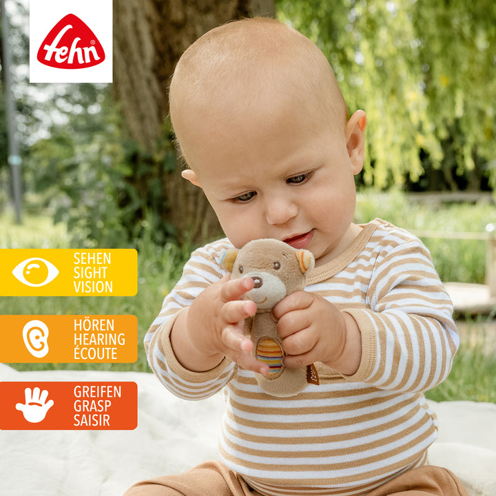 Baby spielt mit Plüsch-Mini-Rassel Teddy