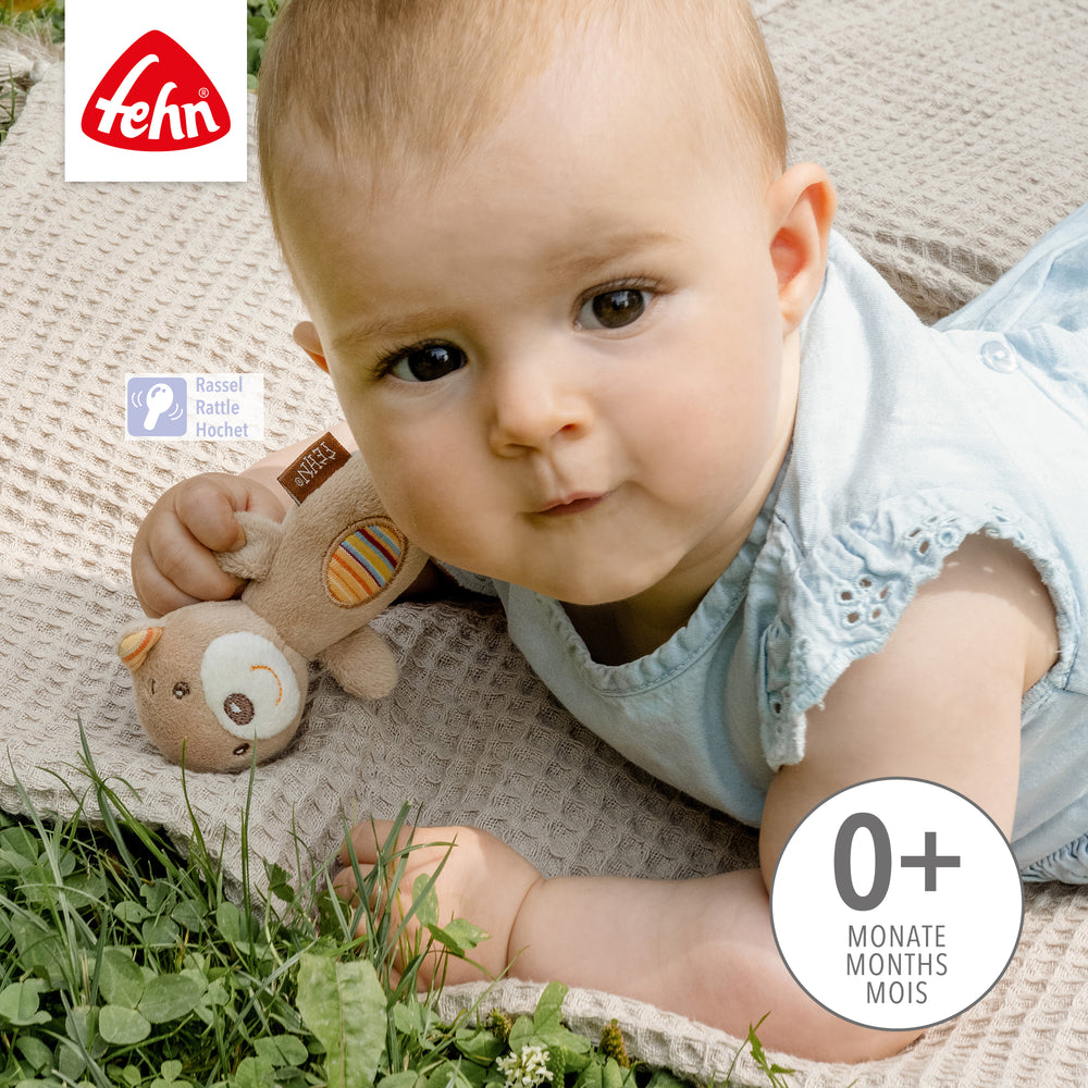 Baby hält Baby Mini-Rassel Teddy